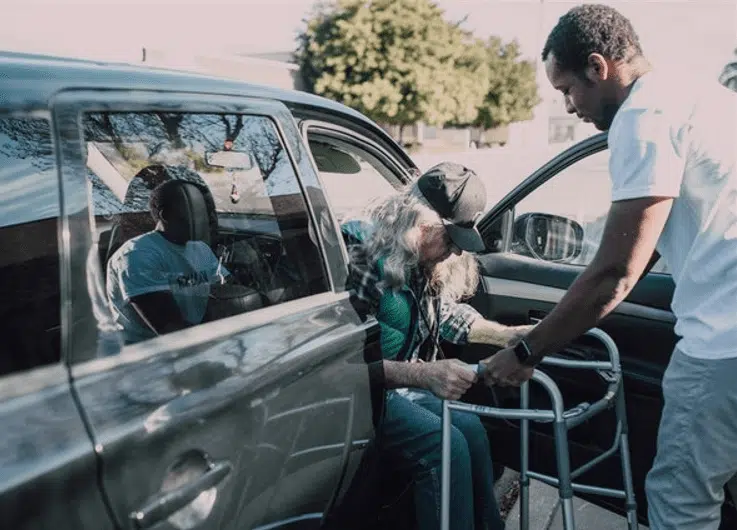 Man helping elderly man out of car