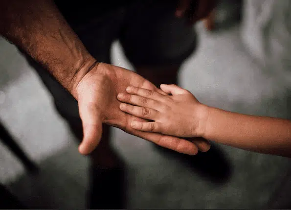 Father holding hands with child