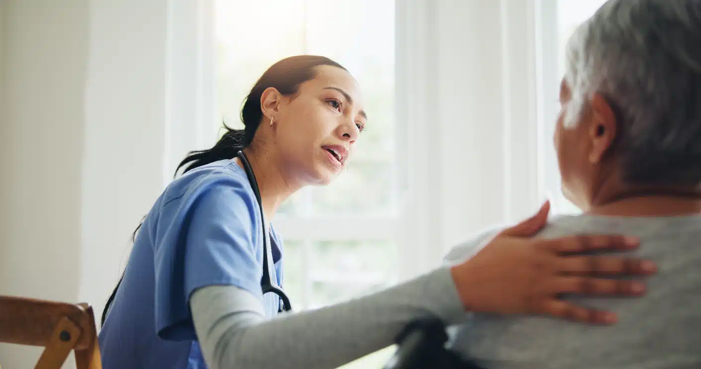 Woman, nurse and senior patient in wheelchair for elderly care, support or trust at old age home. Medical doctor or caregiver listening to person with a disability or consulting for health advice